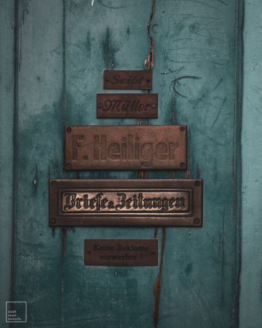 🇩🇪 „Ein Name auf dem Türschild“

Vor dieser alten Tür frage ich mich: Wer waren die Menschen, deren Namen hier eingraviert wurden? Welche Hände haben wohl einst diese Klinke gedrückt, welche Geschichten trugen sie mit sich? Ein Türschild ist mehr als eine Namensplakette – es ist ein Symbol für Zugehörigkeit, für einen Ort, den jemand Heimat nannte.

Doch so wie die Patina auf dem Metall verblasst, so verblassen auch die Erinnerungen an jene, die hier lebten. Wir alle werden zu Namen auf einem Türschild, zu einem Kapitel in der Geschichte eines Hauses. Unsere Leben verweben sich unbemerkt mit den Spuren, die andere hinterlassen haben – ein stiller Tanz von Vergangenheit und Gegenwart, bewahrt von diesen alten Wänden.

🇬🇧 “A Name on the Doorplate”

Looking at this old door, I can’t help but wonder: Who were the people whose names are engraved here? What hands once turned this handle, what stories did they carry with them? A doorplate is more than just a name tag – it’s a symbol of belonging, of a place someone called home.

But just as the patina fades on the metal, so do the memories of those who lived here. We all become names on a doorplate, a chapter in the story of a house. Our lives quietly intertwine with the traces left by others – a silent dance of past and present, preserved by these old walls.

#altbau #geschichtenerzähler #geschichten #alltagsgeschichten #türschild #zeitspuren #lebenimaltbau #architekturgeschichte #haustüren #patina #homesweethome #vergangenheit #gegenwart #wortzumsonntag #nikon #nikonphotography #mood #moodygrams #instamood #doorsofinstagram #doorsworldwide #doors #türen